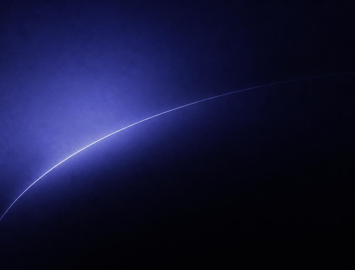 Deep indigo gradient field crossed by a single fine orbital arc